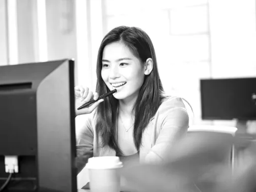 Approachable smiling woman working at PC