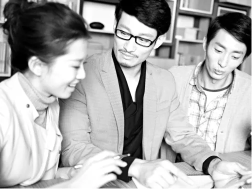 3 young Asian business people working in an office